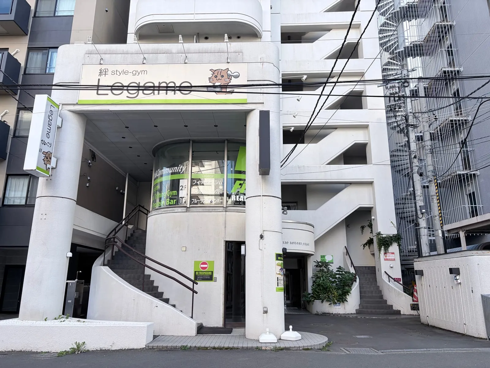 建物の正面外観。2階の「絆 style-gym Legame」看板と1階入口、外階段