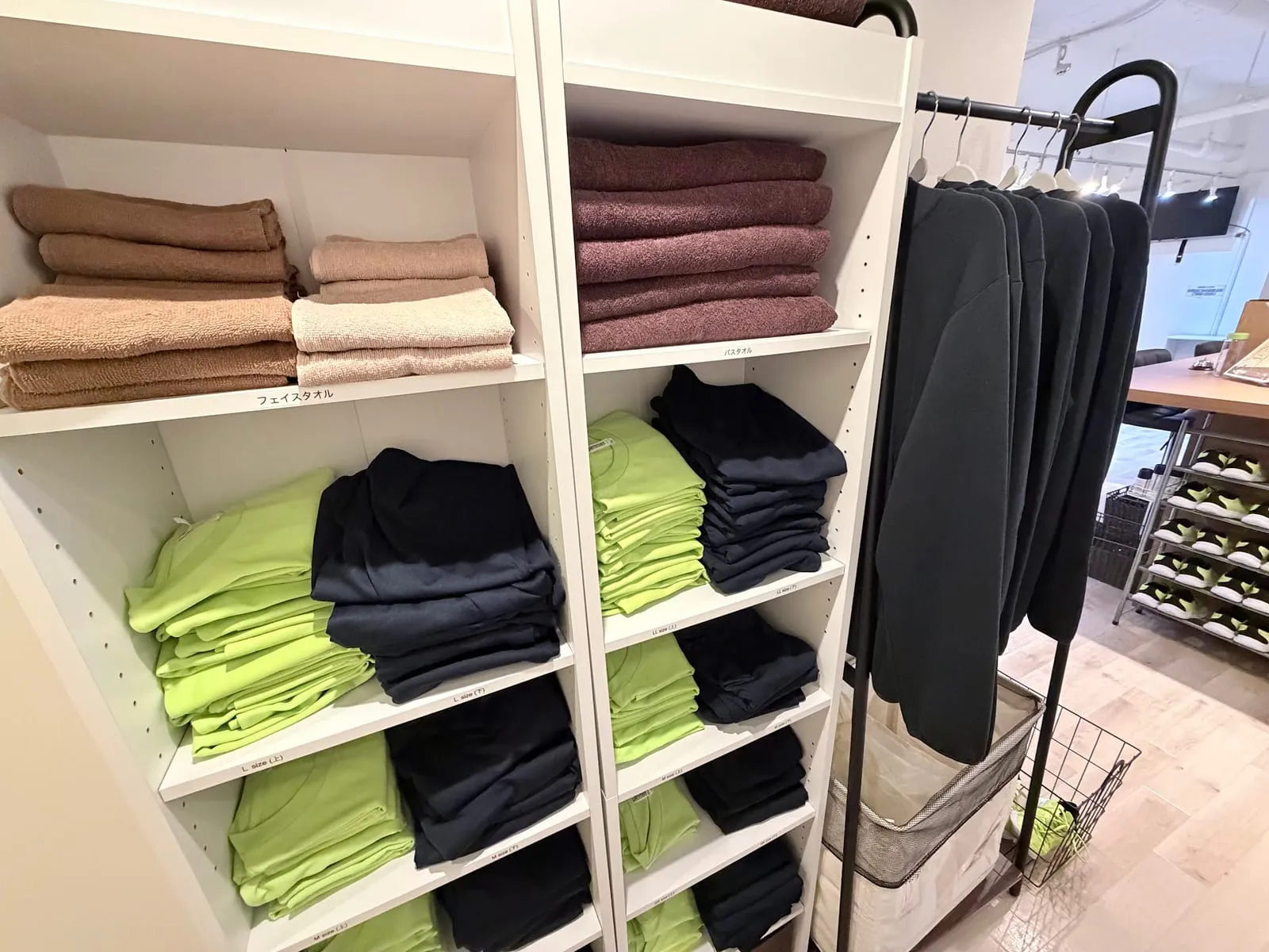 レンタルウェアとタオルの棚（黄緑と黒のTシャツ、タオル）