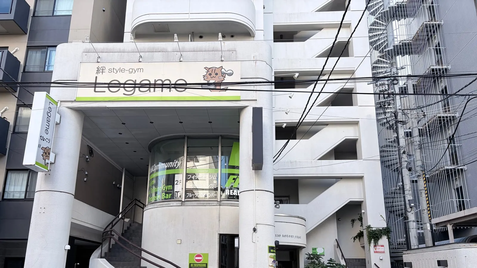 建物の正面外観。2階の「絆 style-gym Legame」看板と1階入口、外階段
