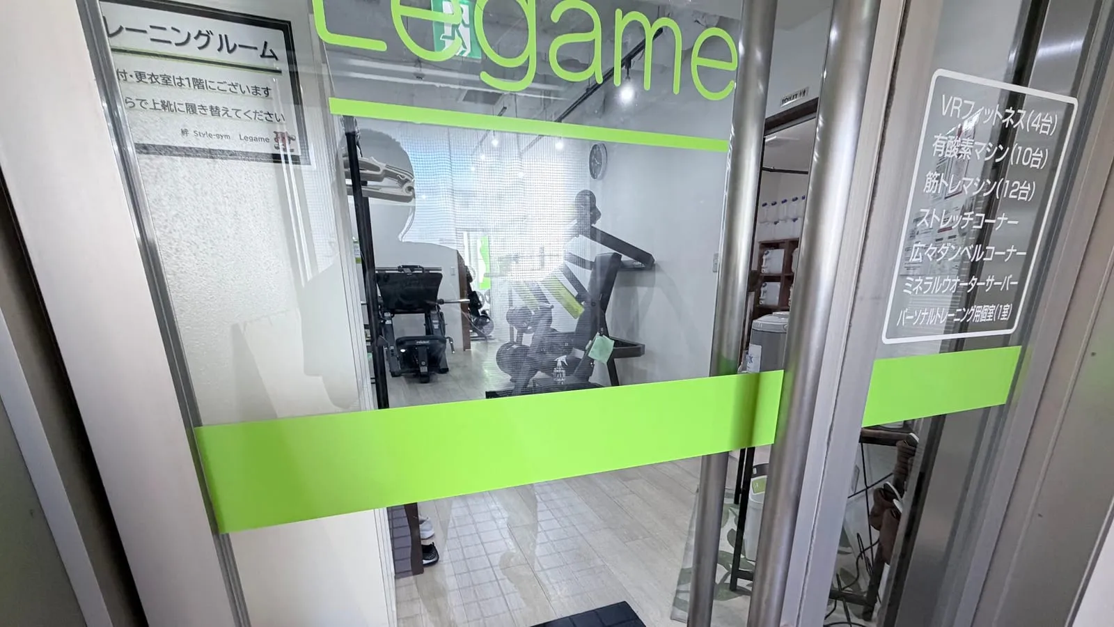 2階トレーニングルームのガラス扉（Legameのロゴと黄緑の帯）