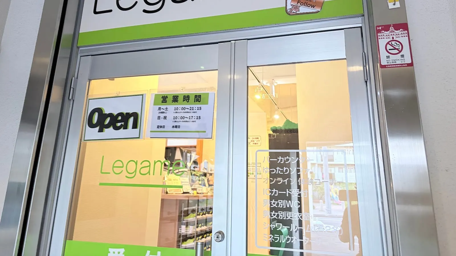1階入口のガラスドア。「絆 style-gym Legame」の看板と営業時間の掲示、Open の表示